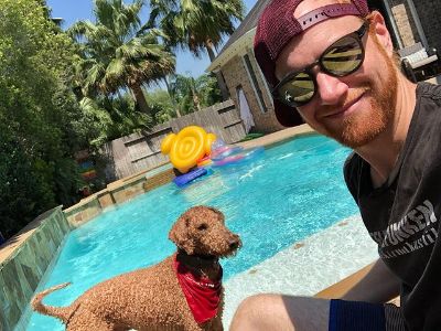 Austen Hooks is taking this selfie by the pool as Bullet looks on.